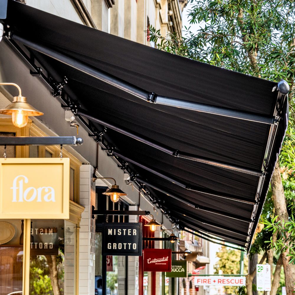 Aria Folding Arm Awning by Outdoor Blinds and Awnings (OBA) for H. May Precinct by Green Anvil Co